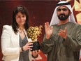Canadian teacher Maggie MacDonnell (L) receives the Global Teacher Prize from Sheikh Mohammed bin Rashid al-Maktoum, vice-president and Prime Minister of the UAE and Ruler of Dubai, during a ceremony in Dubai on March 19, 2017.