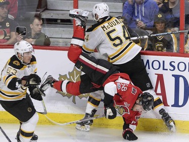 Ottawa Senators' Mike Hoffman (68) gets upended after a collision with Boston Bruins' Adam McQuaid (54) as Brad Marchand (63) skates by during second period NHL hockey action in Ottawa, Monday March 6, 2017.