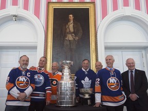 Governor General David Johnston (right) poses with former NHL players Bryan Trottier (left to right), Paul Coffey, Bernie Parent, Frank Mahovlich, Dave Keon, Mike Bossy, the original Stanley Cup and the Stanley Cup during an event commemorating the Cup's 125th anniversary at Rideau Hall, Thursday, March 16, 2017 in Ottawa.