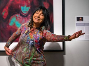 Buffy Sainte-Marie strikes a pose in front of her artwork called "The Mohawk Warrior Contemplates His Future", during a media preview of the Ottawa Art Gallery Annex exhibit of Art is Art at Ottawa City Hall.