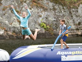 Maks and sister Zoya Thompson-Arnold have fun jumping off the trampoline at their cottage and into the cool waters of Lac de la Trinité.
