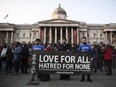 People hold up a banner at Trafalgar Square on March 23, decrying the attack at Westminster.