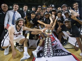 The Carleton Ravens pose for a team photograph with the W. P. McGee Trophy after defeating the Calgary Dinos to win the school's 11th Canadian university men's basketball final at Vancouver on March 20, 2016.