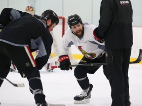 Chris Neil, left, and Zack Smith practise in the faceoff circle during the Senators' workout at the Bell Sensplex on Monday. 
Jean Levac/Postmedia