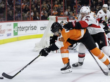 Philadelphia Flyers' Chris VandeVelde, left, reaches for a loose puck against Ottawa Senators' Mark Borowiecki during the second period of an NHL hockey game, Tuesday, March 28, 2017, in Philadelphia.