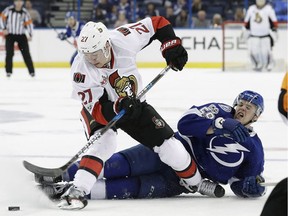 Curtis Lazar gets pulled down by Lightning defenceman Jake Dotchin during the third period of the Senators' game in Tampa on Feb. 2.