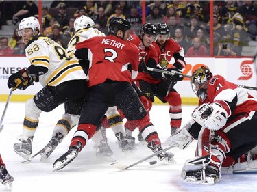 Ottawa Senators goaltender Craig Anderson (41) controls the puck as Boston Bruins' David Pastrnak (88) is hit by Senators' Marc Methot (3) during first period NHL hockey action in Ottawa, Monday March 6, 2017.