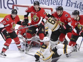 Mike Hoffman, middle, joins a crowd of Senators players helping out defensively in front of goalie Craig Anderson during Monday's game against the Bruins at Canadian Tire Centre..