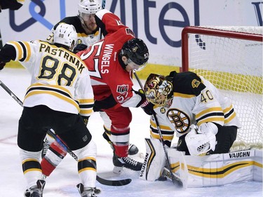 Ottawa Senators' Tommy Wingels (57) tries get the puck past Boston Bruins goaltender Tuuka Rask (40) as David Pastrnak (88) looks on, during second period NHL hockey action in Ottawa, Monday March 6, 2017.