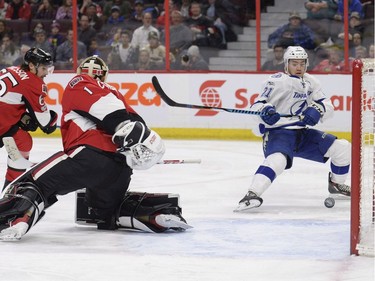 Tampa Bay Lightning's Brayden Point (21) watches his shot go into the net for a goal against Ottawa Senators goaltender Mike Condon (1) as Senators' Erik Karlsson (65) looks on during first period NHL hockey action, in Ottawa, Tuesday, March 14, 2017.