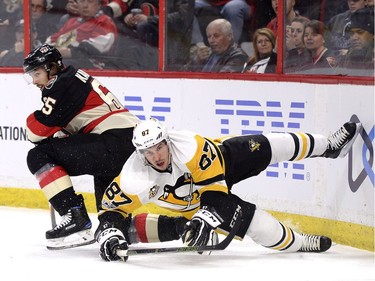Ottawa Senators' Erik Karlsson (65) and Pittsburgh Penguins' Sidney Crosby (87) get tangled up during first period NHL hockey action in Ottawa, Thursday March 23, 2017.