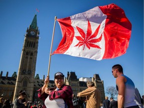 (FILES) This file photo taken on April 20, 2016 shows a woman waving a flag with a marijuana leaf on it next to a group gathered to celebrate National Marijuana Day on Parliament Hill in Ottawa, Canada.   Prime Minister Justin Trudeau's Liberals will introduce legislation in the coming weeks which would legalize the recreational use of marijuana in Canada by the middle of next year, reports said on March 27, 2017. Trudeau's Liberal caucus was briefed on the timeline for the proposed measure during a weekend meeting, public broadcaster CBC reported, citing unnamed sources.  /