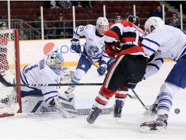 Goalie Jacob Ingham looks for the puck with Artur Tyanulin pressing hard and Stefan LeBlanc looking to help out in the first period as the Ottawa 67's take on the Mississauga Steelheads in game 4 in Ontario Hockey League playoff action at TD Place Arena.