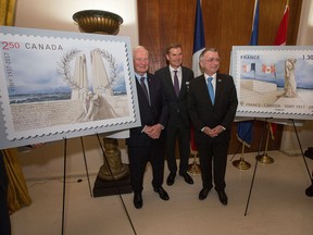 From left, Gov. Gen. David Johnston, Bruce Burrows, chair of the 2017 Vimy Reception Committee, and French Ambassador to Canada Nicolas Chapuis assist La Poste of France unveil two commemorative stamps designed in honour of the 100th anniversary of the Battle of Vimy Ridge.