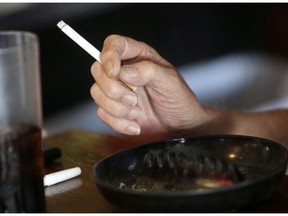 In this Tuesday, April 21, 2015 file photo, a patron smokes a cigarette inside a bar in New Orleans. THE CANADIAN PRESS/AP/Gerald Herbert ORG XMIT: CPT111