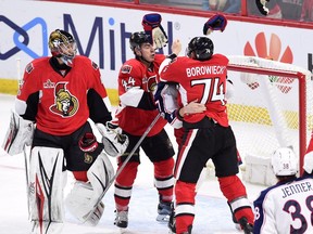 Gloves fly off as Senators defenceman Mark Borowiecki (74) and starts a scrap with Blue Jackets centre Brandon Dubinsky after Dubinsky dumped goalie Craig Anderson behind the net in the first period on Saturday night.