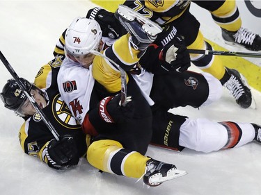 Ottawa Senators defenseman Mark Borowiecki (74) tangles with Boston Bruins defenseman Torey Krug, bottom, during the first period of an NHL hockey game in Boston, Tuesday, March 21, 2017.