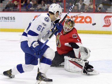 Ottawa Senators' goalie Mike Condon (1) makes a save as Tampa Bay Lightning's Yanni Gourde (65) looks on during first period NHL hockey action in Ottawa, Tuesday, March 14, 2017.