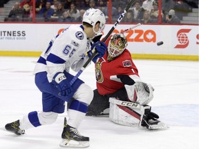 Senators goalie Mike Condon makes a save as the Lightning's Yanni Gourde (65) looks on during the first period of Tuesday's game.