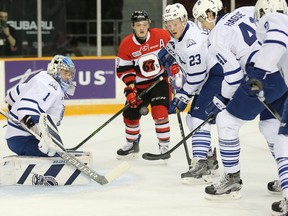 67's winger Artur Tyanulin can't get to the puck quick enough as Steelheads goalie Jacob Ingham keeps his eye on it with help from a pack of teammates during the first period of Tuesday's game.  Wayne Cuddington/Postmedia