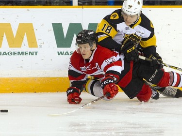 Ottawa 67's #13 Artur Tyanulin tries to reach the puck as he and Hamilton Bulldogs #18 Matthew Strome fumble to the ground during the first period of action Sunday March 19, 2017 at TD Place Arena.   Ashley Fraser/Postmedia