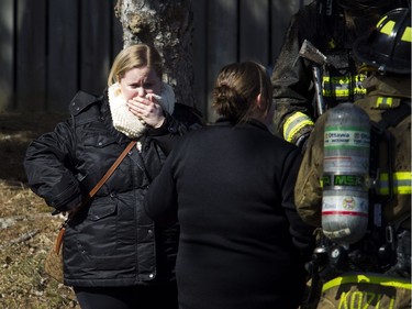 Ottawa firefighters were battling a four-alarm blaze in the Baseline-Merivale area at 34 Northview Rd., a strip of rowhouse apartments Saturday March 12, 2017. A distraught woman takes a moment as she is speaking with firefighters Sunday.