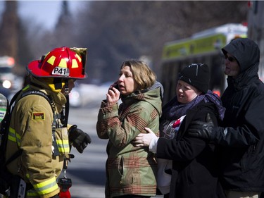 Ottawa firefighters were battling a four-alarm blaze in the Baseline-Merivale area at 34 Northview Rd., a strip of rowhouse apartments Saturday March 12, 2017. Axelle Manley who lost her home and animals speaks to a fire fighter on the scene. Manley was happy her and her four year old daughter escaped uninjured from the fire but was very upset over the loss of her pets.