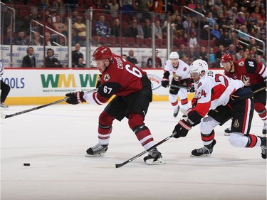 Lawson Crouse #67 of the Arizona Coyotes skates in with the puck ahead of Viktor Stalberg #24 of the Ottawa Senators during the first period of the NHL game at Gila River Arena on March 9, 2017 in Glendale, Arizona.