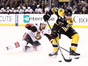 BOSTON, MA - MARCH 21: Erik Karlsson #65 of the Ottawa Senators slides to defend Brad Marchand #63 of the Boston Bruins during the first period at TD Garden on March 21, 2017 in Boston, Massachusetts.