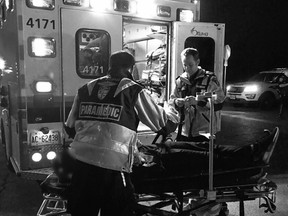 Paramedics treat a victim at a crash in Gloucester Friday.