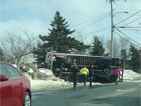 People look on as a truck lies on its side in Paradise, N.L. on Saturday, March 11, 2017 in this handout photo.
