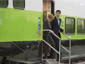 Prime Minister Justin Trudeau, right, and Ontario Premier Kathleen Wynne disembark from a train before making a policy announcement at GO Transit's Willowbrook Rail Maintenance Facility in Toronto on Friday, March 31, 2017.