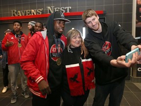 Carleton Ravens champions Emmanuel Owootoah and Connor Wood get a selfie taken with Lorna Van Duyse after returning to campus in Ottawa Monday March 13, 2017. Carleton won their 13th national basketball title in Halifax over the weekend.  Tony Caldwell