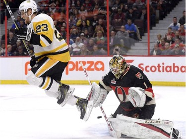 Pittsburgh Penguins' Scott Wilson (23) jumps out of the way of a shot as Ottawa Senators goaltender Mike Condon (1) watches the puck during first period NHL hockey action in Ottawa, Thursday March 23, 2017.