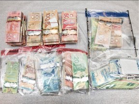 Seized cash from a drug raid is seen in this undated handout photo. A dozen Ottawa residents are facing a total of more than 130 charges following a drug investigation related to the trafficking of counterfeit pills containing the deadly opioid fentanyl.