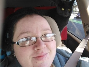 Sarah Rowland, with Winston the cat peering over her shoulder. Winston was feared dead following a massive fire that destroyed dozens of apartments, including the home of Rowland and partner Michael Kolorz.