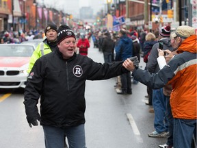 Jeff Hunt greets fans standing along Bank Street during the parade to celebrate the Redblacks' victory in the 2016 Grey Cup game.  Wayne Cuddington/ Postmedia