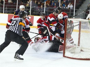 Colts players crash into the 67's crease, but netminder Leo Lazarev keeps the puck out on this occasion during Sunday's game at TD Place arena.   Ashley Fraser/Postmedia