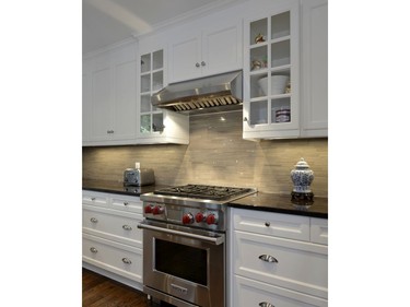 The open concept kitchen now features a plethora of storage space, gorgeous countertops and a brand-new backsplash.