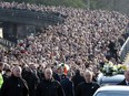 TOPSHOT - The coffin of former Northern Ireland Deputy First Minister Martin McGuinness is carried through the Bogside area of Derry, for burial at the City Cemetery of Derry on March 23, 2017.   Former Irish Republican Army commander turned peace negotiator Martin McGuinness divided opinion both in life and in death but on Thursday his supporters gave him the funeral of an Irish chieftain. /
