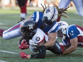 Alouettes linebacker Bear Woods tackles tailback Travon Van, then with the Redblacks, in a game on June 30, 2016.