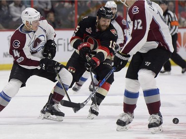 Ottawa Senators Zack Smith (15) tries to control the puck against Colorado Avalanche Tyson Barrie (4) during first period NHL hockey action in Ottawa, Thursday, March 2, 2017.