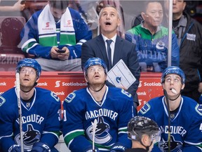 Vancouver Canucks' head coach Willie Desjardins, top, stands on the bench during a game against the Washington Capitals in Vancouver, B.C., on Oct. 29, 2016.