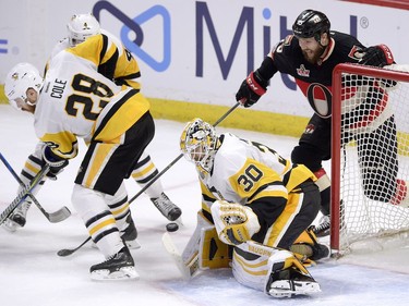Pittsburgh Penguins goalie Matthew Murray (30) keeps his eye on the puck as Ian Cole (28) tries to keep Ottawa Senators' Zack Smith (15) away, during second period NHL hockey action in Ottawa, Thursday, March 23, 2017.