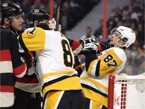 The Ottawa Senators' Zack Smith (15) grabs on to the Pittsburgh Penguins' Sidney Crosby (87) during the first period at the Canadian Tire Centre on Thursday March 23, 2017.