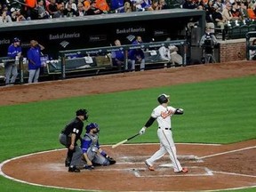Baltimore Orioles' Chris Davis watches his solo home run in front of Toronto Blue Jays catcher Russell Martin and home plate umpire Eric Cooper during the fourth inning of a baseball game in Baltimore, Wednesday, April 5, 2017.