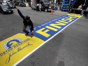 A skateboarder jumps over the newly applied Boston Marathon finish line on Boylston St., Thursday, April 13, 2017, in Boston. The finish line is made from an adhesive decal that covers a painted version that is left in place throughout the year. The 121st Boston Marathon is to be run Monday, April 17. (AP Photo/Steven Senne)
