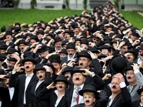 662 peoples dressed as Charlie Chaplin pose for a group photo in front of the Manoir de Ban during an attempt of the world&#039;s largest gathering of people dressed as The Tramp on the occasion of Charlie Chaplin&#039;s birthday, and to celebrate the first year of the museum &ampquot;Chaplin&#039;s World by Grevin&ampquot;, in Corsier-sur-Vevey, Switzerland, Sunday, April 16, 2017. (Laurent Gillieron/Keystone via AP)