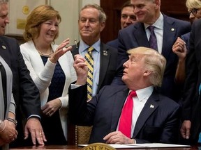 President Donald Trump gives his pen to a teacher from Virginia after signing the Education Federalism Executive Order during a federalism event in the Roosevelt Room of the White House in Washington, Wednesday, April 26, 2017. (AP Photo/Andrew Harnik)