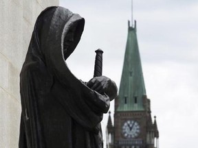 The Peace tower on Parliament Hill is seen behind the justice statue outside the Supreme Court of Canada in Ottawa, Monday June 6, 2016. The federal Liberals came to power promising sweeping reforms to the criminal justice system, but now the provinces are championing some ideas of their own as they focus on cutting backlogs in the courts. THE CANADIAN PRESS/Adrian Wyld